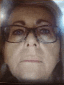 a close up of a woman 's face with glasses on .