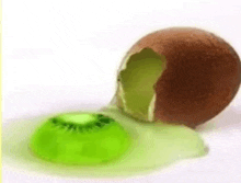 a green kiwi is sitting next to a broken kiwi on a table .