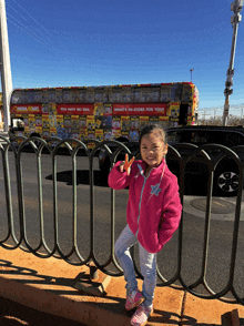 a little girl stands in front of a omega mart truck