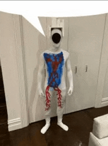 a man in a costume with blood coming out of his chest is standing in a room .