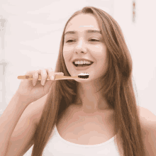 a woman is brushing her teeth with a toothbrush that says ' lg ' on it