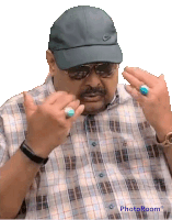 a man wearing a plaid shirt and a nike hat shows off his rings on his fingers