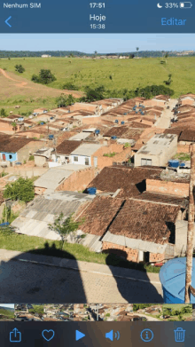 a phone screen shows a picture of a village with the time of 17:51