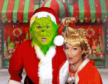 a woman dressed as grinch and a man dressed as santa