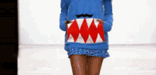 a woman wearing a blue sweater with shark teeth and mustache