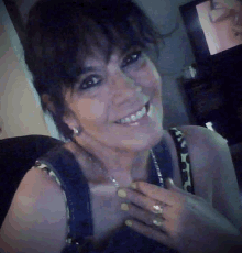 a woman with a ring on her finger is smiling and looking at the camera