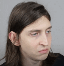 a close up of a person 's face with a gray background