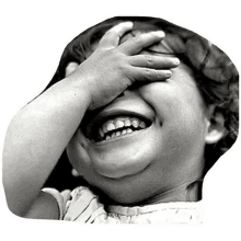 a black and white photo of a little girl covering her eyes with her hand while laughing .