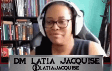 a woman wearing headphones and a sign that says dm latia jacquese