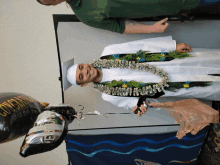 a man in a graduation cap and gown with a congratulations balloon behind him