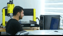 a man is sitting in front of a machine that has the letter n on it