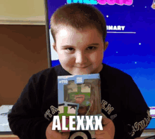 a young boy is holding a toy that says alexxx