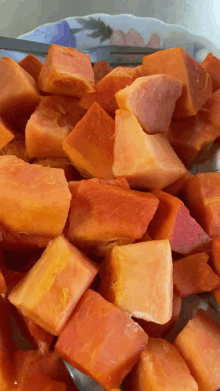 a plate of sliced papaya on a table with a fork