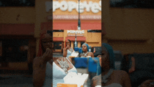 a woman in front of a popeyes restaurant