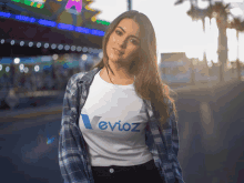 a woman wearing a white t-shirt that says ' evioz ' on it