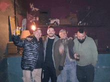 a group of men are posing for a picture and one man is holding a glass of beer