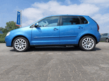 a blue car is parked in front of a sign that says wipro