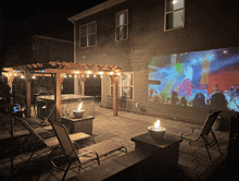 a large screen is projected on the side of a house at night