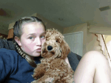 a girl sitting on a couch with a small brown dog