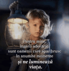 a little girl is holding a lantern with a quote on it