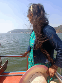 a woman sitting on a boat looking out over the water