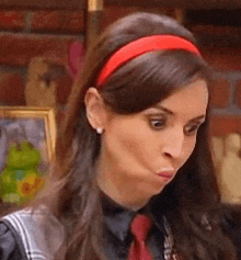 a close up of a woman wearing a red headband and a red tie .