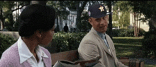 a man and a woman are sitting on a bench and the man is wearing a hat with a star on it