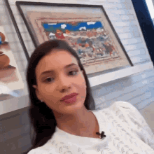 a woman is sitting in front of a framed painting