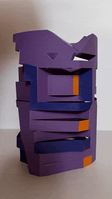 a purple sculpture with orange stripes on the bottom