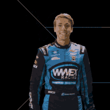 a man wearing a blue wnex racing jacket waves