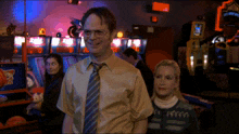 a man and a woman are standing in an arcade with a sign that says ' basketball ' on it