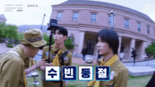 a group of young men are standing in front of a large building with chinese writing on it .