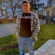 a young man wearing a guess shirt and plaid shirt