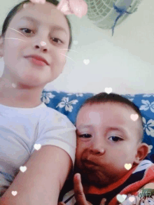 a girl and a boy are posing for a picture and the girl is wearing a white shirt with hearts on it