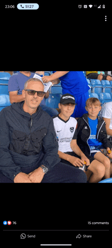 a group of people sitting in a stadium with one wearing a jersey that says university of portsmouth