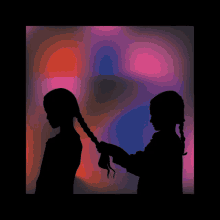 a girl braids another girl 's hair in a silhouette