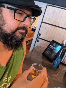 a man with glasses and a beard is holding a shot glass in his hand