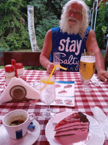 a man sits at a table wearing a blue shirt that says stay salty