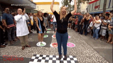 a woman is dancing on a checkered floor in front of a crowd with the word sabrina on the bottom