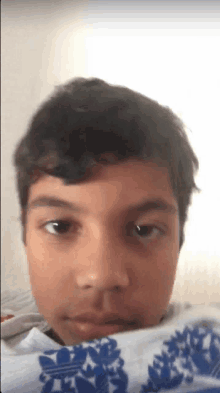 a close up of a person 's face with a blue and white adidas shirt on