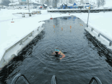 a person is swimming in a body of water with a sign that says ' swimming ' on it