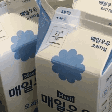 two cartons of maeil milk are sitting next to each other on a table