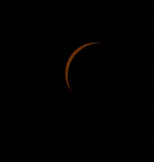 a partial eclipse of the sun is seen in the night sky .