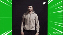 a man in a hoodie is standing in front of a twitter logo