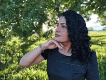 a woman in a black dress is standing in a field