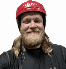 a man with a beard is wearing a red helmet that says jofa on it