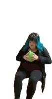 a woman with blue hair is sitting on a chair holding a green ball