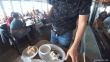 a man in a black shirt is standing in front of a table with plates of food and a sign that says sub goat