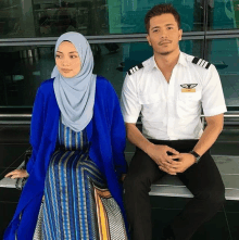 a man in a pilot uniform sits next to a woman