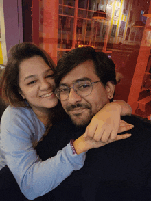 a man and a woman are posing for a picture and the woman is wearing a bracelet that says " i love you "